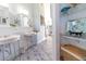Bright bathroom featuring double sinks, glass shelves with decor, and blue-tiled floors at 3000 Ocean Shore Blvd # 18, Ormond Beach, FL 32176