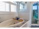 Bright bathroom featuring a soaking tub and a shower with white tiles at 3000 Ocean Shore Blvd # 18, Ormond Beach, FL 32176
