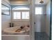 Bright bathroom featuring a soaking tub and a shower with blue tiles at 3000 Ocean Shore Blvd # 18, Ormond Beach, FL 32176