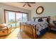 Bright bedroom with a wooden frame bed, ocean view, comfortable armchair, and a wooden bedside table at 3000 Ocean Shore Blvd # 18, Ormond Beach, FL 32176