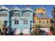 Multi-colored townhome exterior featuring a two-car garage, balcony, and tropical foliage at 3000 Ocean Shore Blvd # 18, Ormond Beach, FL 32176