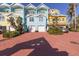 Exterior view of colorful townhouses with brick paved driveways and mature landscaping at 3000 Ocean Shore Blvd # 18, Ormond Beach, FL 32176