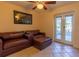 Well-lit living room features leather sofas, tile flooring, ceiling fan, and sliding door access to the outside at 3000 Ocean Shore Blvd # 18, Ormond Beach, FL 32176