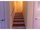 Clean staircase with wooden steps and white risers connecting levels, complemented by neutral wall colors at 3000 Ocean Shore Blvd # 18, Ormond Beach, FL 32176