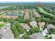 An aerial view of a residential neighborhood with mature trees, a pond, and a golf course with a clubhouse in the distance at 3132 Connemara Dr, Ormond Beach, FL 32174