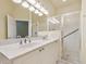 Bright bathroom features a double vanity, large mirror, and glass-enclosed shower at 3132 Connemara Dr, Ormond Beach, FL 32174