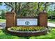 Acoma Entrance with colorful flowers, a brick sign, and manicured landscaping for a welcoming neighborhood entry at 3132 Connemara Dr, Ormond Beach, FL 32174
