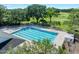 Aerial view of a pristine community pool surrounded by lush greenery, perfect for relaxation and recreation at 3132 Connemara Dr, Ormond Beach, FL 32174