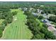 An aerial view of the golf course and the clubhouse which features a swimming pool, tennis courts, and golf cart parking at 3132 Connemara Dr, Ormond Beach, FL 32174