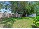 Fenced backyard featuring lush green grass and mature trees, providing a private outdoor oasis at 466 Leland Dr, Deltona, FL 32725
