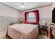 Comfortable bedroom with pink floral wallpaper, a plush bed, and vintage-style furniture at 466 Leland Dr, Deltona, FL 32725
