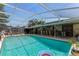 Exterior view of a home with a screened pool area featuring a bar, seating, and a refreshing pool at 466 Leland Dr, Deltona, FL 32725