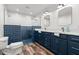 Contemporary bathroom featuring dual vanity sinks, blue tile accents, and glass-enclosed shower at 1026 Bel Aire Dr, Daytona Beach, FL 32118