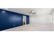 Spacious bedroom with bright white walls, blue accent wall, ceiling fan, and view into the closet at 1026 Bel Aire Dr, Daytona Beach, FL 32118