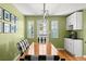 Open dining area with a wood table, natural light, white cabinets, and decor against a green wall at 1026 Bel Aire Dr, Daytona Beach, FL 32118