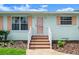 Inviting entryway with updated shutters, desert landscaping, and a charming painted front door at 1026 Bel Aire Dr, Daytona Beach, FL 32118