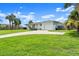 A charming single-story home with a manicured lawn, palm trees, and an attached garage in a tranquil setting at 1026 Bel Aire Dr, Daytona Beach, FL 32118