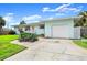 Attractive single-story home with shutters, attached garage, and desert landscaping along the driveway at 1026 Bel Aire Dr, Daytona Beach, FL 32118