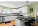 Modern kitchen with white cabinets, stainless appliances, bar seating, and view to the living room at 1026 Bel Aire Dr, Daytona Beach, FL 32118
