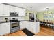 A well-lit kitchen with stainless steel oven, white cabinets, granite countertop and an opening to the dining room at 1026 Bel Aire Dr, Daytona Beach, FL 32118