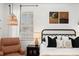 Close up of the main bedroom with a wicker light fixture and brown leather accent chair at 1026 Bel Aire Dr, Daytona Beach, FL 32118