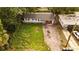 Aerial view of a single-story home with a new roof, tidy front yard, and driveway, surrounded by lush trees at 1131 Martha Dr, Daytona Beach, FL 32114