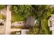 Aerial view of a home with a shingle roof surrounded by lush trees and some vehicles at 1131 Martha Dr, Daytona Beach, FL 32114