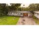 Single-story home featuring a tidy front yard, light blue paint, and a driveway, surrounded by lush trees at 1131 Martha Dr, Daytona Beach, FL 32114