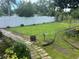 Backyard featuring green grass, white fencing, a bird bath, and landscaping at 1218 Daytona Ave, Daytona Beach, FL 32117