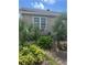Exterior view of the home's side, with lush landscaping and an A/C unit at 1218 Daytona Ave, Daytona Beach, FL 32117
