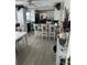 Bright kitchen with modern white cabinets, black appliances, a gray counter bar with stools, and laminate flooring at 1218 Daytona Ave, Daytona Beach, FL 32117