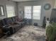 Comfortable living room with recliner sofa, large windows, and a patterned rug at 1218 Daytona Ave, Daytona Beach, FL 32117