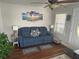 Cozy living room with blue sofa, wall art, and hardwood floors at 1218 Daytona Ave, Daytona Beach, FL 32117