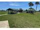 Community playground with a play structure and picnic tables beneath covered shelters at 1218 Daytona Ave, Daytona Beach, FL 32117