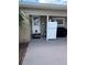 Side entrance of the home with gray concrete, white refrigerator, and grill at 1218 Daytona Ave, Daytona Beach, FL 32117