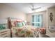 Cozy bedroom with vibrant bedding, modern ceiling fan, and city view window at 231 Riverside Dr # 1602, Holly Hill, FL 32117