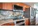 Modern kitchen features stainless steel appliances and a stylish stone backsplash and countertops at 231 Riverside Dr # 1602, Holly Hill, FL 32117