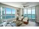 Bright living room with floor-to-ceiling windows offering stunning views, comfortable seating, and stylish decor at 231 Riverside Dr # 1602, Holly Hill, FL 32117