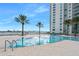 Inviting swimming pool with poolside seating, views of the waterfront, and lush tropical landscaping at 231 Riverside Dr # 1602, Holly Hill, FL 32117