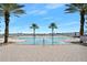 Beautiful swimming pool surrounded by palm trees, with views of the river and city skyline at 231 Riverside Dr # 1602, Holly Hill, FL 32117