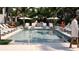 Community pool surrounded by lounge chairs and palm trees at 2360 Ocean Shore Blvd # 17, Ormond Beach, FL 32176