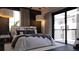Comfortable bedroom featuring a balcony, textured accent wall, and stylish lighting fixture at 2360 Ocean Shore Blvd # 7, Ormond Beach, FL 32176