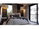 Comfortable bedroom featuring a balcony, textured accent wall, and stylish lighting fixture at 2360 Ocean Shore Blvd # 7, Ormond Beach, FL 32176