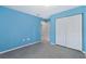 A bright bedroom with gray carpet, light blue walls, white closets, and view to the bathroom at 2531 Needle Palm Dr, Edgewater, FL 32141