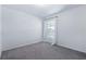 A minimal bedroom with gray carpet, white walls, and a window with white sheer curtains at 2531 Needle Palm Dr, Edgewater, FL 32141