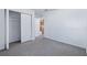 A bright bedroom with gray carpet, white walls, and a view to the kitchen through the doorway at 2531 Needle Palm Dr, Edgewater, FL 32141