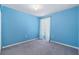 A bright bedroom with gray carpet, a window with white curtains, and light blue walls at 2531 Needle Palm Dr, Edgewater, FL 32141