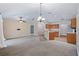 Open-concept living room and kitchen with carpeted floors and modern lighting fixtures at 2531 Needle Palm Dr, Edgewater, FL 32141