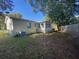 View of the backyard featuring a well-defined property line, mature trees, and an air conditioning system at 264 Sherwood Ln, Daytona Beach, FL 32117