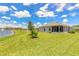 Spacious backyard featuring well-manicured lawn, lake, and screened patio at 2836 Monaghan Dr, Ormond Beach, FL 32174